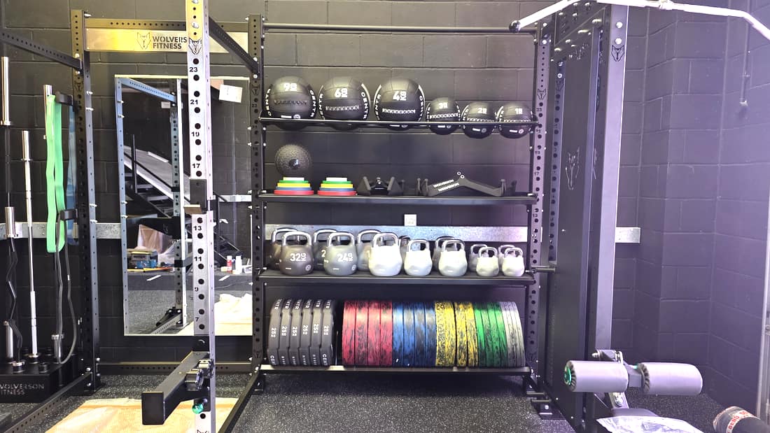 Wall balls, kettlebells and weight plates racked at Effortless Gym Poole